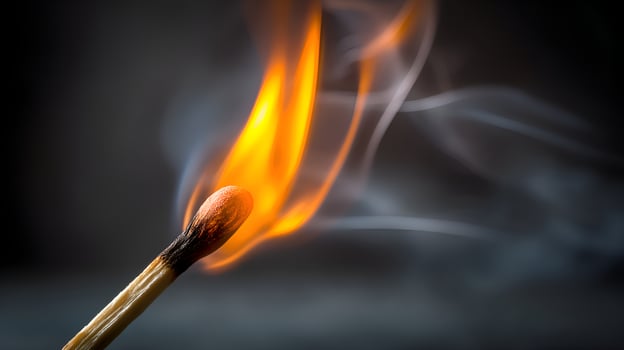 Burning match with smoke on dark background generating fire photo