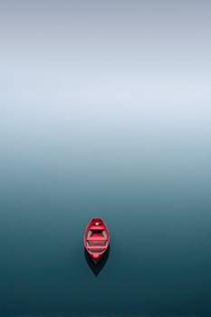 Bright red boat rests serenely in calm, turquoise water with soft gradient backdrop photo