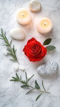 Bright candles and rose adorn marble with stones and rosemary branches elegantly arranged photo