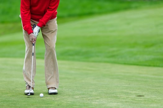 Golf Player in Red Sweater Putting Ball on Green Field Closeup Outdoor Sports Action or Training Game photo