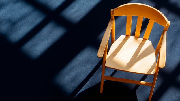 Minimalist flat lay of an empty wooden directors chair on a deep navy blue photo
