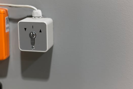 Key operated wall switch on gray wall photo