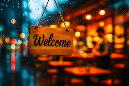 A welcome sign hanging on a window in a restaurant photo