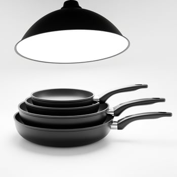 Three black frying pans on a white surface photo