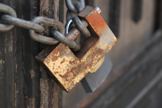 Rusty padlock securing a heavy chain on a wooden door photo