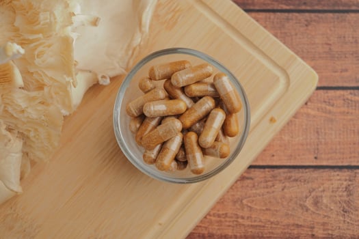 Natural herbal capsules on wooden kitchen surface photo