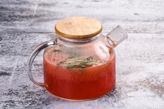 A pitcher of red liquid with a wooden lid photo