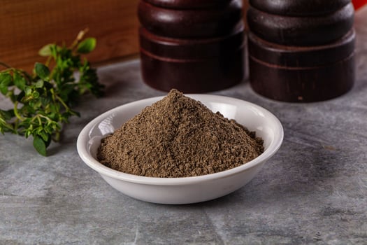 A bowl of brown powder sitting on a table photo
