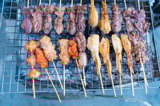 Many roasted skewers of barbecue on grill photo