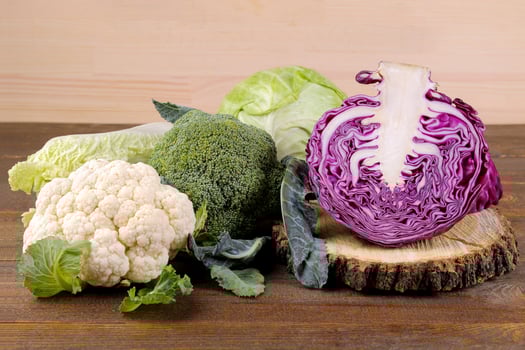 Many different kinds of cabbage on a brown wooden background. photo