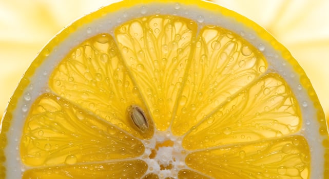 Macro shot of a lemon slice displaying juicy segments and glistening water droplets under bright light photo