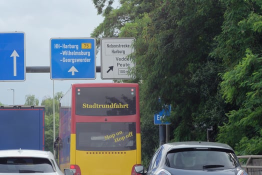 Vehicles and Direction Signs on German Urban Roadway and a tourist bus with Stadtrundfahrt on it photo