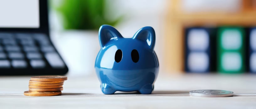 blue piggy bank surrounded by coins and calculator photo