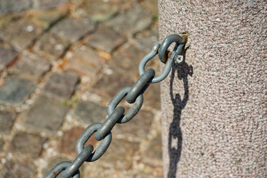 Concrete Post with Metal Hook and Attached Chain photo