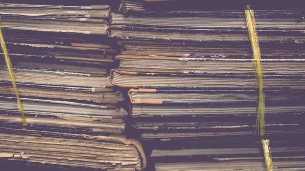 A stack of old books with yellow tape photo