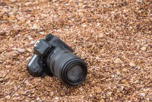 A camera laying on the ground in a field of gravel photo
