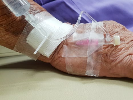 A patient's hand with an iv and a drip photo
