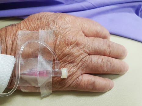 A person with a hand holding an iv drip photo