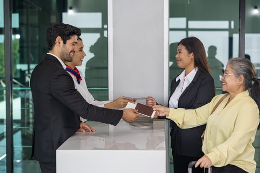 Asian senior passenger is showing boarding pass to the airline ground crew at departure gate into the airplane for final inspection before boarding into plane photo