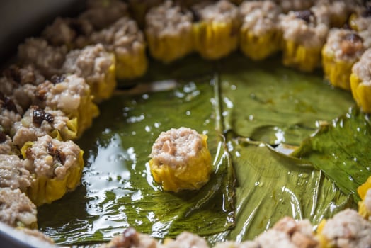 A pan filled with meat and vegetables on a leaf photo