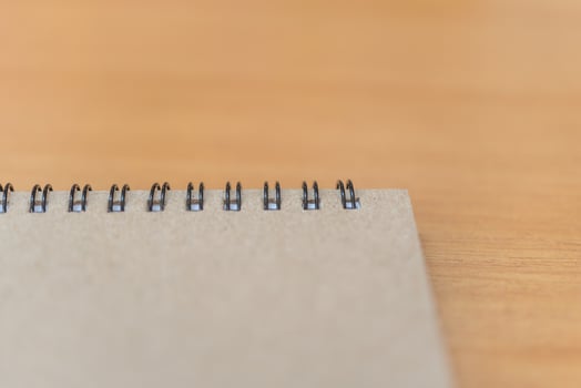 A notebook with a spiral notebook on top of a wooden table photo