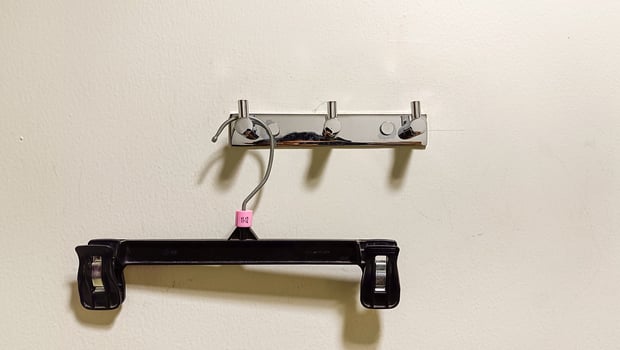 An empty clothes hanger hanging on the wall in a fitting room photo