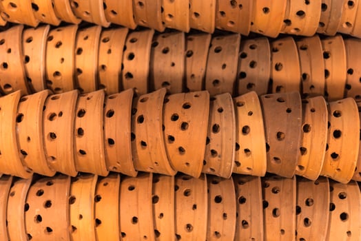 A pile of brown leather belts with holes photo