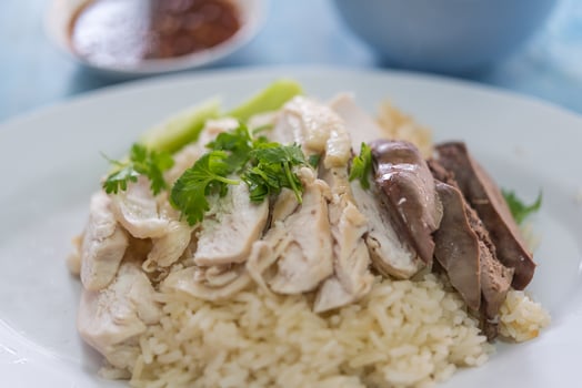 A plate of rice and chicken with a side of sauce photo