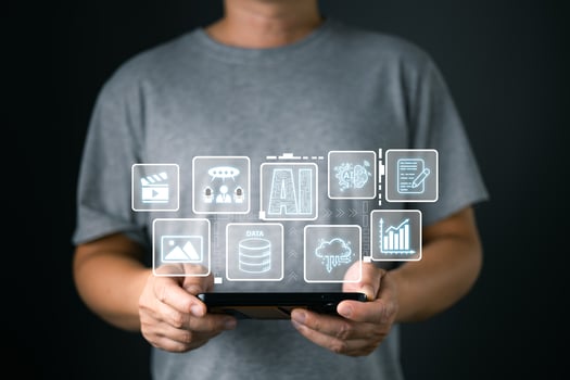 A man holds an AI icon while using a mobile, representing marketers who conduct research and analysis on media, focus on content creation, and develop strategies to grow their digital business. photo