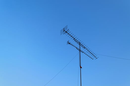 A television antenna on a pole in the sky photo