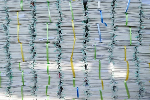 A pile of paper with green and yellow ribbons photo