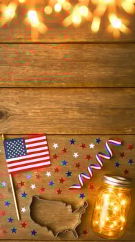 American Flag, Mason Jar Lights, Confetti And Ribbon On Wooden Table photo