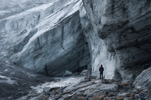 Exposed Rock Beneath Melting Glacier with Lone Observer photo