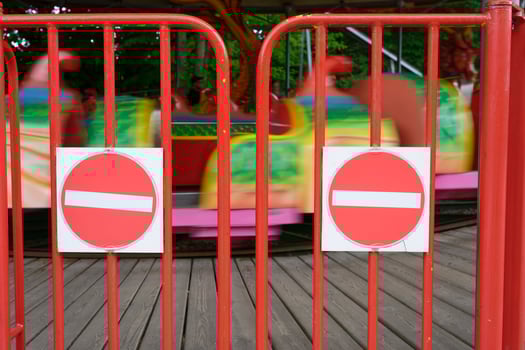 Closed children carousel with red barrier and warning signs photo