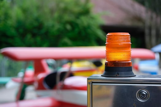 Orange warning lamp on metal box near children helicopter rides photo