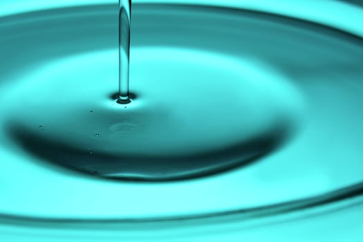Pouring oil in blue tones. The texture of a cosmetic or other oil product. photo