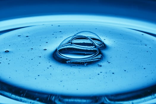 Mouth-watering bubbles in a drop of cosmetics in blue tones. photo