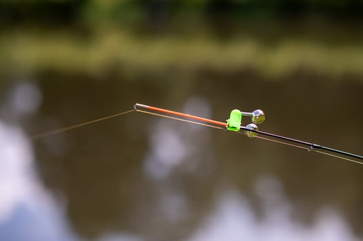 A fishing rod with a green and orange tip photo