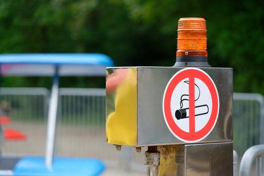 Metal post with no smoking sticker and yellow warning light outdoors photo