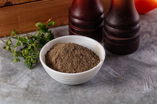 A bowl of powder next to two bottles of sauce photo