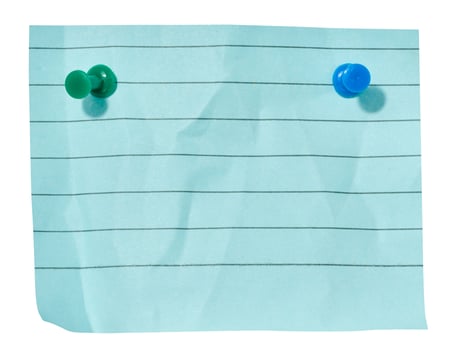 Sheet of blue lined paper attached with two red pushpins on an isolated background photo