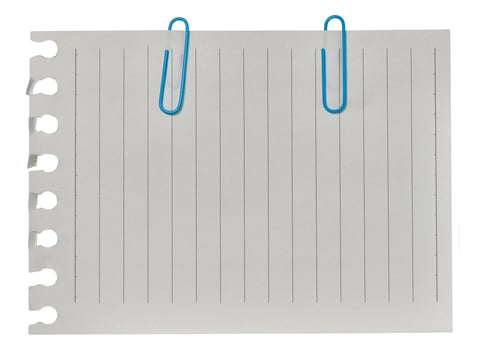 A sheet of white lined paper attached with two blue paper clips to a white surface with a curved edge at the bottom. photo