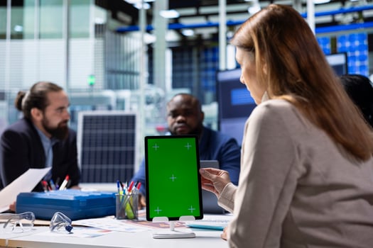 Photovoltaics factory workers analyzing data, reviewing system health metrics with isolated screen tablet. Solar panels plant employees troubleshooting technical issues using mockup device photo