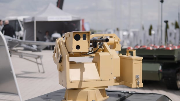 A remote-controlled weapon system is prominently showcased at a military technology expo, highlighting advancements in defense and robotic warfare technology. photo