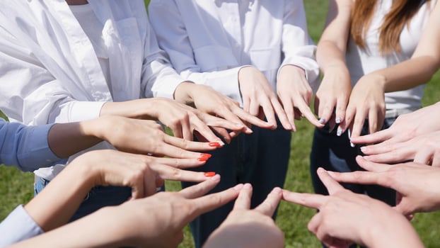A vibrant and exciting gathering showcasing synchronized hand gestures in a warm, sunny outdoor setting photo
