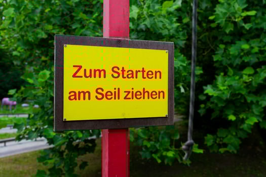 Red metal pole with yellow German sign and pull instruction photo