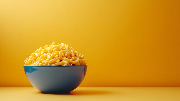 A Delicious Bowl of Macaroni and Cheese on a Yellow Background. photo