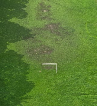Portable steel mini goal. Mini goalpost for kid's soccer or football game in the green field. Soccer field top view photo