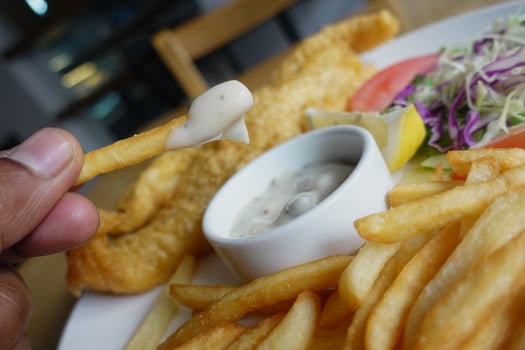 Delicious fish and chips served with tartar sauce photo