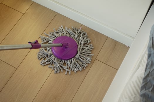 Cleaning the floor with a mop in a bright room photo